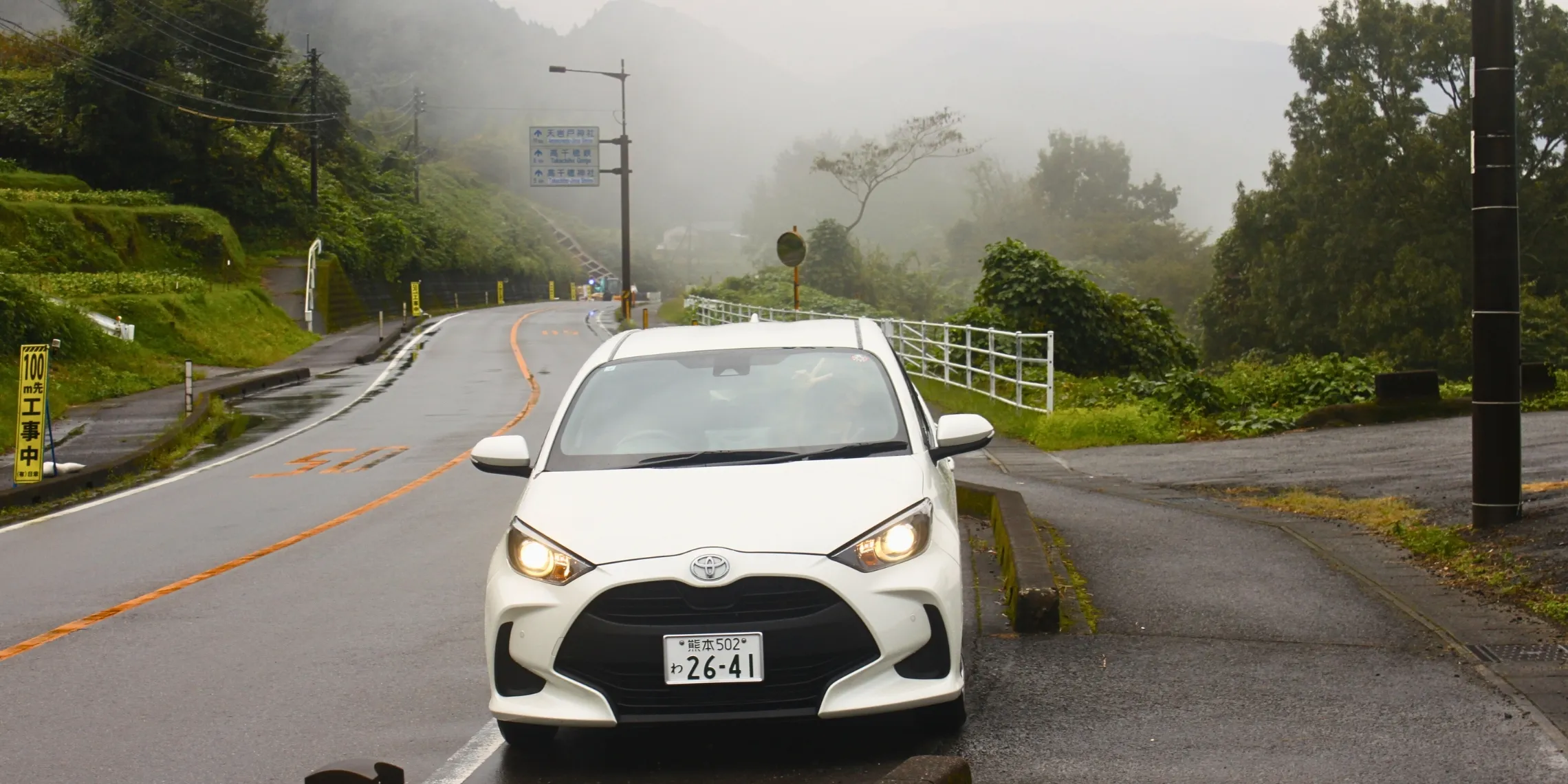Weißer Mietwagen auf nebliger Straße in der Miyazaki-Präfektur