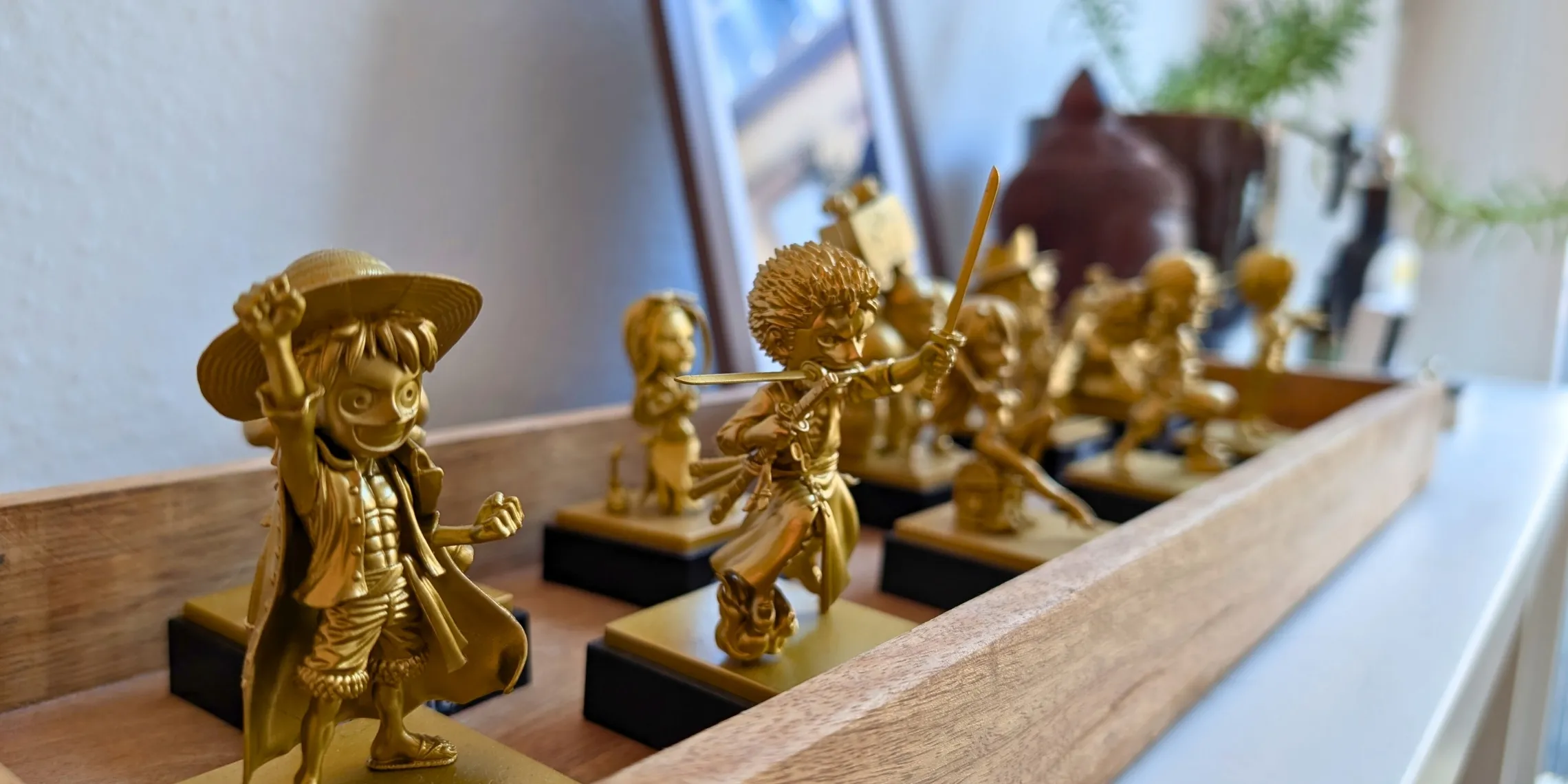 Nahaufnahme der zehn goldenen Collectibles, die du auf der One Piece Pilgrimage erwerben kannst