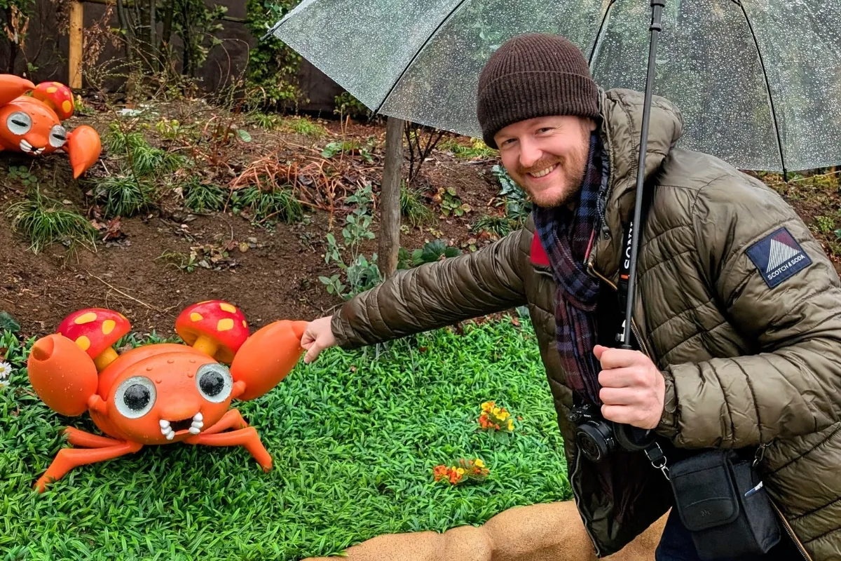 Attraktiver Mann gibt dem Pokemon Paras einen Fist Bump im Pokepark Kanto