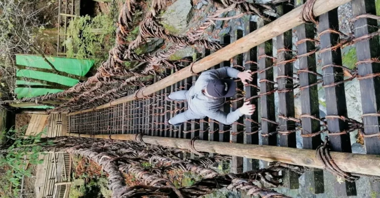 Mann hängt in einer optischen Illusion an der Kazurabashi-Lianenbrücke